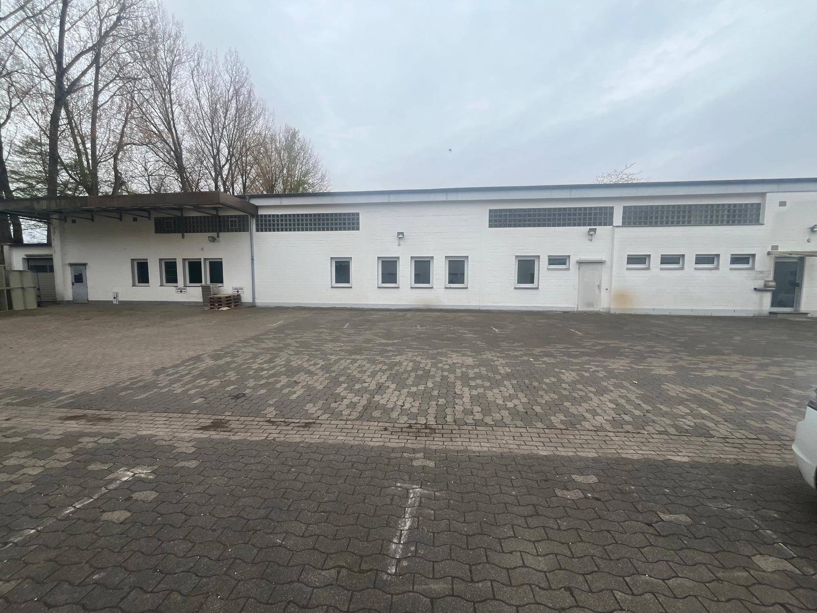 Helle Lagerhalle mit gepflastertem Vorplatz